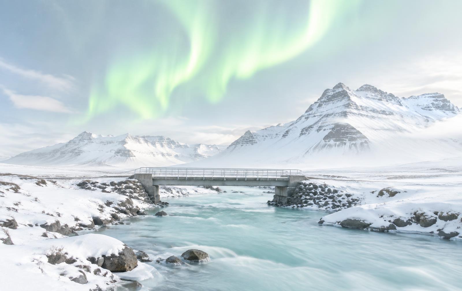 Bridge over a glacial river under the northern lights, Auroracoin wallet migration guides
